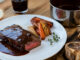 Hovězí steak s tmavou demi-glace omáčkou na talíři