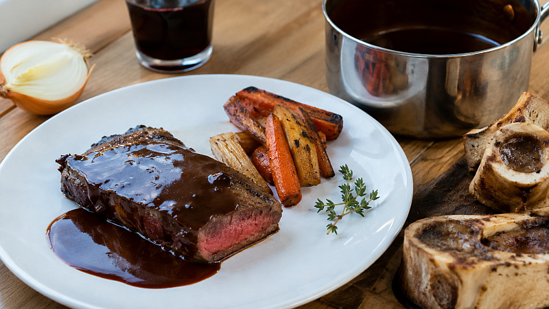 Hovězí steak s tmavou demi-glace omáčkou na talíři